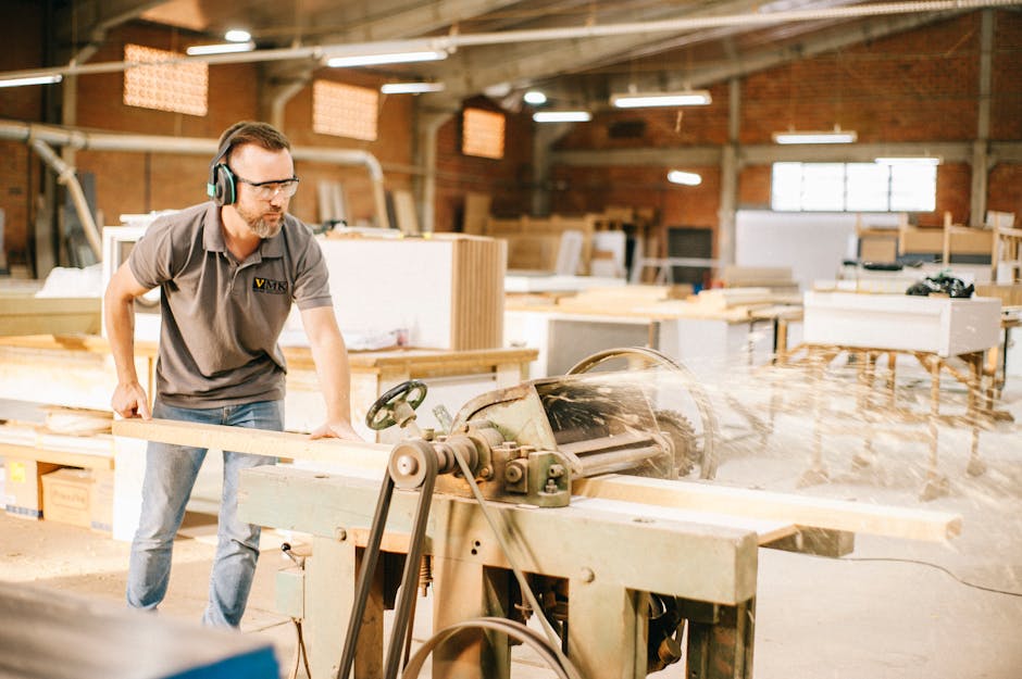Skilled carpenter using machinery in a well-lit woodworking shop.