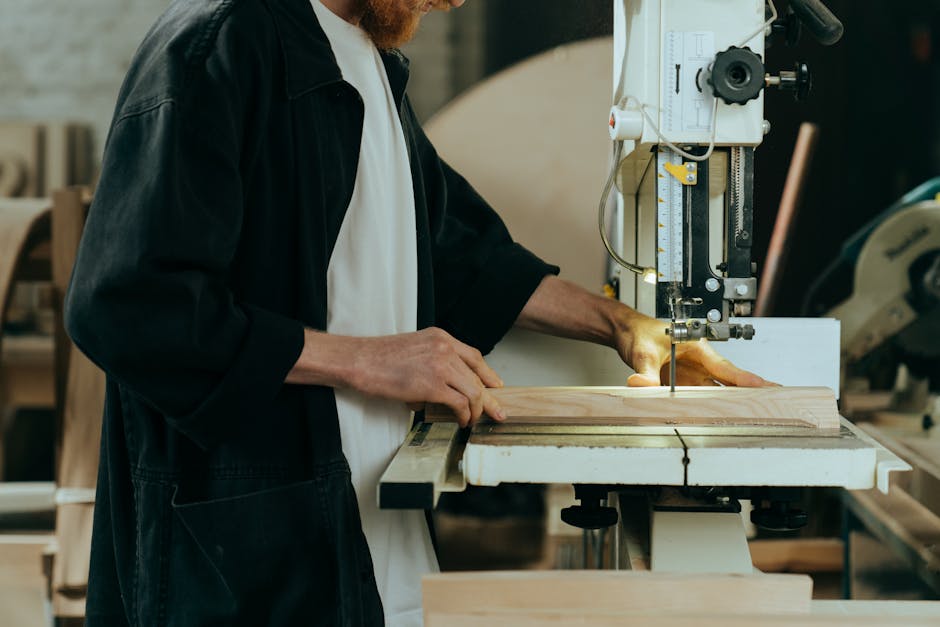 An artisan working with precision on a bandsaw in a professional workshop.